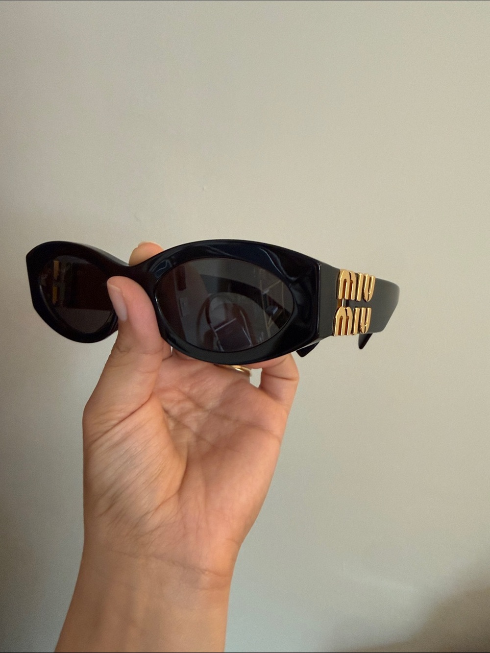 Miu Miu Black Oval Sunglasses with Gold Temple Logos
